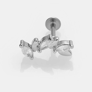 Détail d'un piercing labret en acier argenté avec trois zircons de taille marquise
