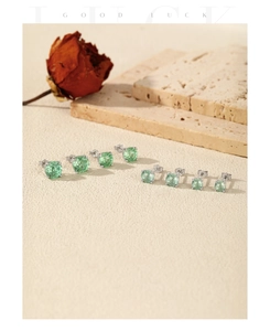Macro view of S925 sterling silver stud earrings with multi-size green gemstone fireworks cut