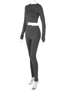 Detail of dark grey two-piece sportswear set featuring long sleeve crop top and high waist leggings