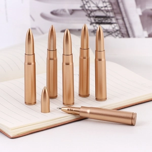 Set di penne a sfera creative a forma di proiettile dorato su un taccuino vintage