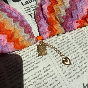 Detail of crochet bikini with zigzag pattern, golden chain and coconut tree pendant