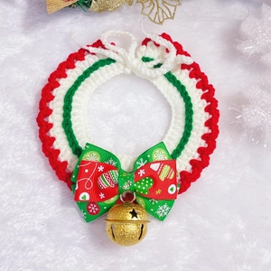 Close-up of knitted pet Christmas collar with ribbon bow and golden star bell