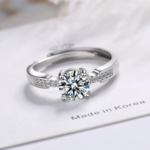Adjustable silver ring with round zirconia main stone and side stones on white background