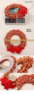 Detail view of a 36cm red Christmas wreath with gold snowflake patterns and a velvet bow
