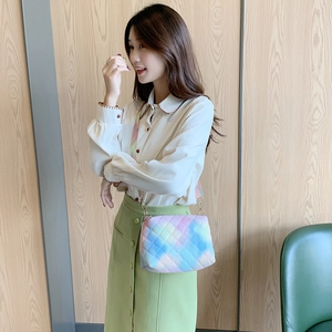 Rainbow gradient crossbody bag with quilted pattern and chain strap on female model