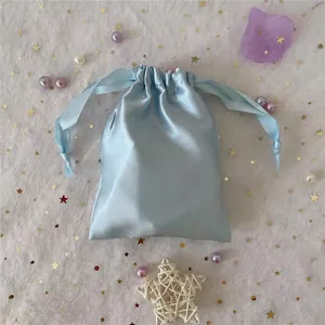 Detail of light blue satin drawstring pouch for jewelry storage with smooth silk finish