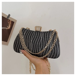 Close-up of black evening bag with silver wave texture and rhinestone buckle