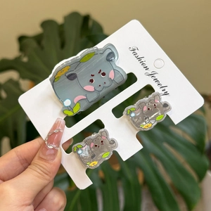 Three-piece set of cute grey hippo hair clips and claw clip on a white card display
