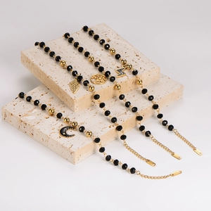 Golden stainless steel bracelets with moon, tree, bolt and leaf charms on black beads