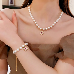 Elegant gold-plated flower bracelet and necklace set with pearls and red gemstones