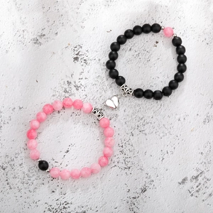 Close-up of magnetic heart clasp connecting natural stone couple bead bracelets