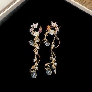 Macro detail of silver needle tassel earrings with butterfly flowers and dangling pearls