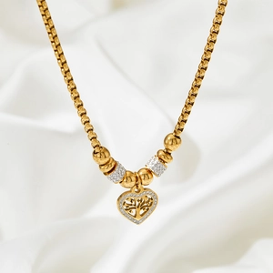 Detailed macro view of a gold heart pendant with tree of life design and sparkling crystals