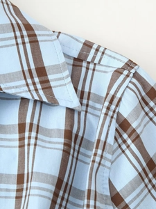 Detail of blue and brown checkered shirt collar with cotton texture and fine stitching