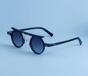 Detail of hip hop punk sunglasses with gold star studs and blue gradient lenses