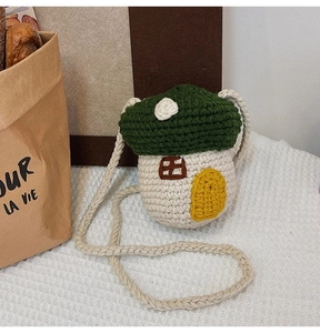 Detailed close-up of a handmade mushroom-shaped knitted crossbody bag with 3D weave texture