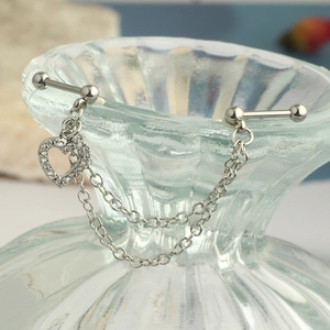 Detail of silver steel heart industrial piercing with zircon pavé and double chain