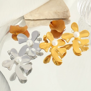 Boucles d'oreilles fleuries élégantes avec perles blanches et pétales sur surface miroir