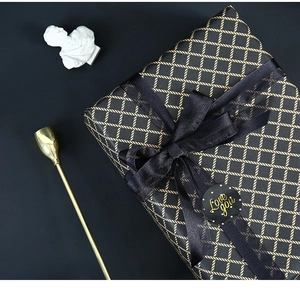 Detail of black gift wrap with gold diamond pattern, sheer ribbon and Love You seal