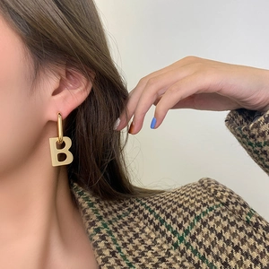 Exaggerated gold B-shaped letter hoop earrings for women with a luxury metallic finish