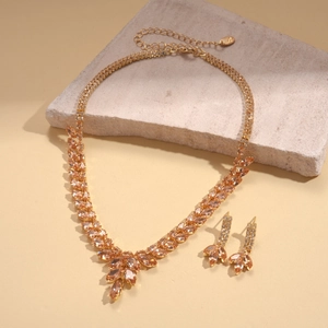 Détail de parure luxe pendentif blé zircon doré et cristaux champagne sur pierre