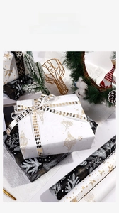 Detail of luxury Christmas gift wrapping paper with gold foil holiday patterns and ribbons