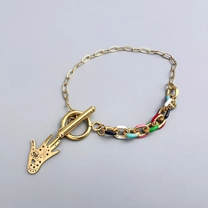 Detail of 18K gold stainless steel bracelet with Hamsa palm charm and colorful enamel link