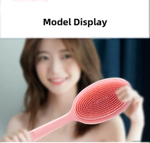 Close-up of pink silicone bath brush with long handle and soft massage bristles