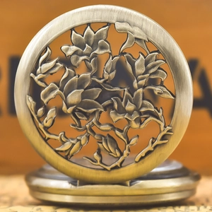 Macro view of retro bronze pocket watch featuring intricate hollow floral cover design