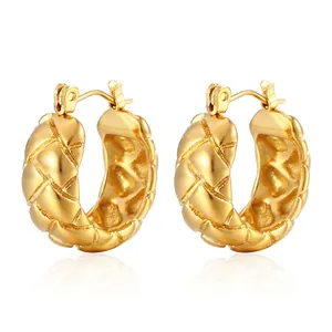 Detail view of gold hoop earrings with embossed geometric pattern and polished finish
