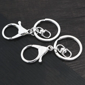 Silver lobster clasp keychain set with swivel link and flat ring on dark wood