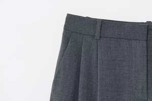 Détail du pantalon gris foncé montrant les passants de ceinture et les poches latérales