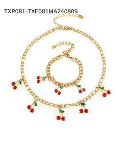 Detailed macro view of cherry charm jewelry set with gold chain and red glass stones