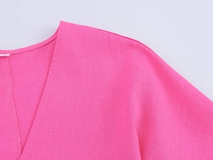 Gros plan détaillé sur le col en V et la texture du tissu en lin respirant rose vif
