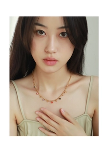 Close-up of 18k gold plated necklace with colorful enamel bead charms on model