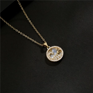 Macro shot of a gold-plated zodiac pendant featuring white shell and cubic zirconia stars