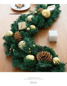 Detail of Christmas garland with pine cones, golden ornaments, and small gift boxes