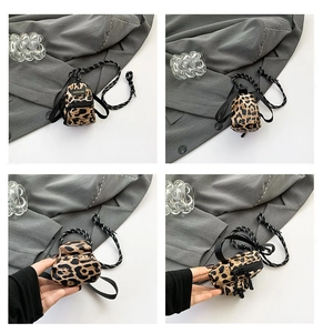 Close-up of leopard print mini cross-body bag with zipper and lanyard details
