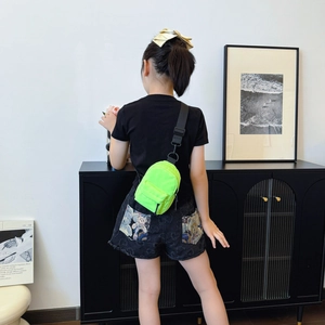 Neon green mini nylon crossbody bag for kids with adjustable black strap on child model