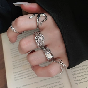 Close-up of geometric irregular silver rings set featuring liquid metal texture design