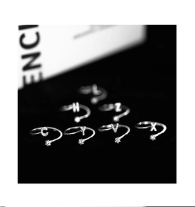 Detail of silver letter rings with sparkling zircon accents and adjustable star end