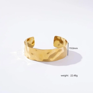 Detailed macro view showing the 19.8mm height and 22.48g weight of the hammered gold bangle
