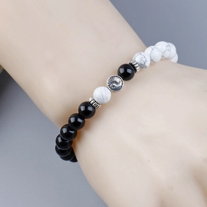 Tai Chi Yin Yang beaded bracelet with black and white pine stone on model wrist