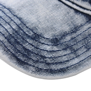 Macro shot of 6-row curved stitching detail on washed denim baseball cap brim