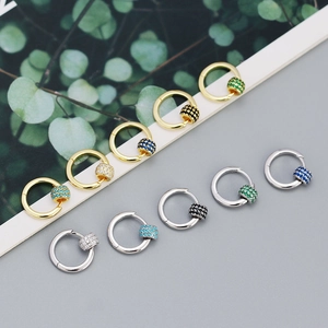 Detail view of stylish gold and silver hoop earrings with colorful zircon cylinders