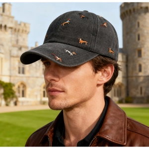Detail of embroidered dachshund patterns on a vintage washed grey cotton baseball cap