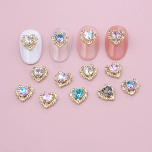 Close-up of heart nail rhinestones in assorted colors on a soft pink background