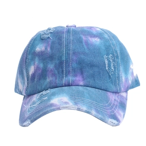 Dettaglio del berretto tie-dye blu e viola con fori distressed e cuciture bianche a vista