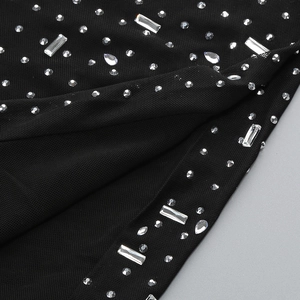 Detail of black mesh fabric featuring intricate rhinestones and fine sewing craftsmanship