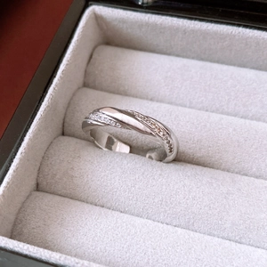Macro shot of twisted silver ring with zircon inlay placed in a grey velvet jewelry box